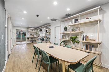 a library with a wooden table and green chairs  at Citrine Hills, Ontario, 91761